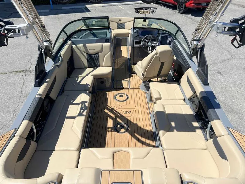 Slide: The Image of 2023 MasterCraft XT24 boat interior with beige seating and teak flooring. - 9