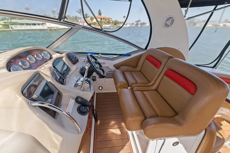 Slide: The Image of Interior cockpit of 2006 Sea Ray 320 Sundancer with brown leather seats and modern controls. - 11