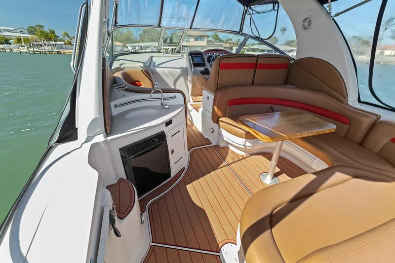 Slide: The Image of 2006 Sea Ray 320 Sundancer interior with seating, table, and helm station. - 13