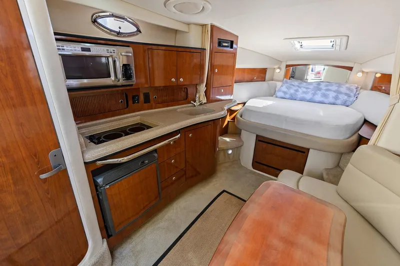 Slide: The Image of 2006 Sea Ray 320 Sundancer interior with kitchen and bed. - 14