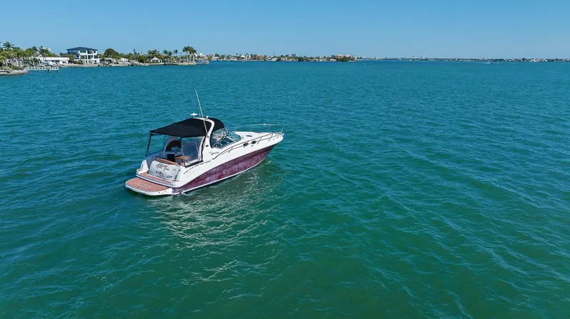 Slide: The Image of 2006 Sea Ray 320 Sundancer cruising on clear blue water. - 19