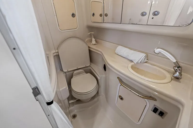 Slide: The Image of 2006 Sea Ray 320 Sundancer bathroom with toilet, sink, and storage cabinets. - 26