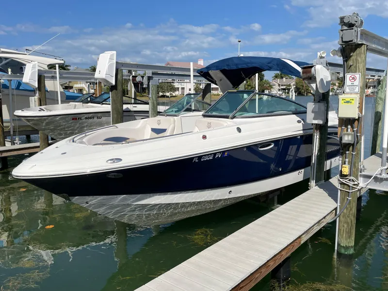Slide: The Image of 2009 Chaparral 276 SSX boat docked at a marina with blue canopy. - 0