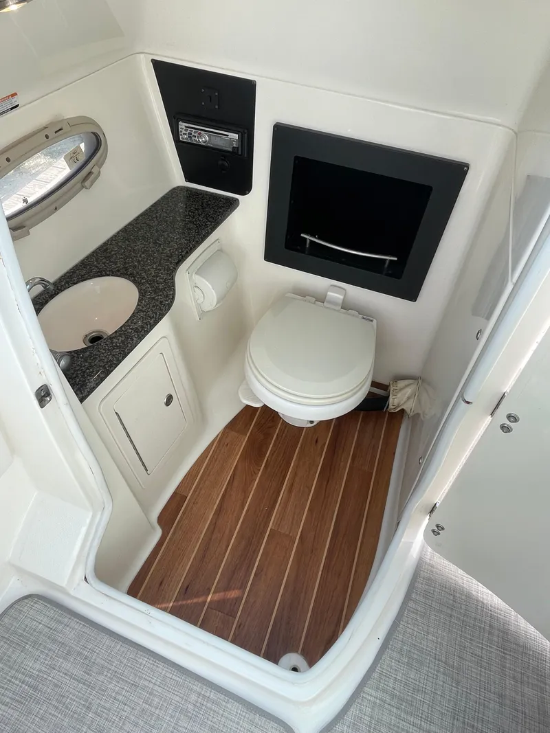 Slide: The Image of 2009 Chaparral 276 SSX boat bathroom with wood flooring, sink, and toilet. - 10