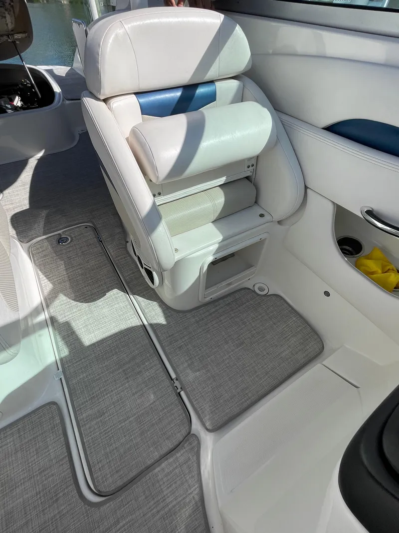 Slide: The Image of 2009 Chaparral 276 SSX boat interior with white leather seating and gray flooring. - 12