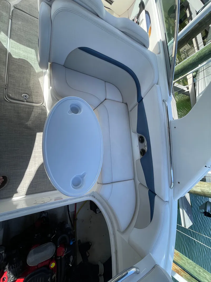 Slide: The Image of 2009 Chaparral 276 SSX boat interior with white and blue seating and a round table. - 19