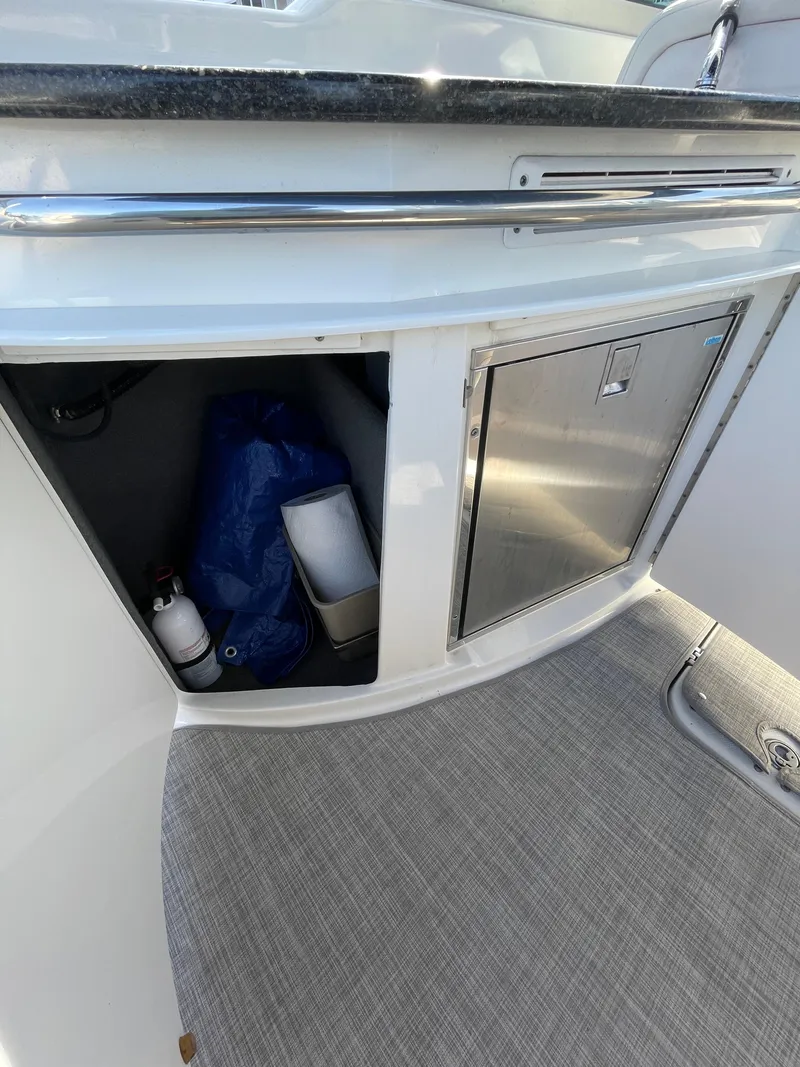 Slide: The Image of 2009 Chaparral 276 SSX boat interior storage compartment and mini fridge. - 20