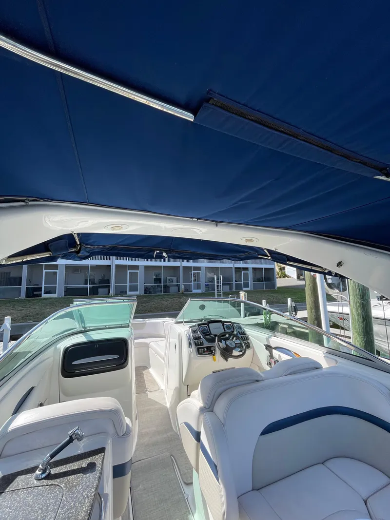 Slide: The Image of 2009 Chaparral 276 SSX boat interior with blue canopy and white seating. - 21