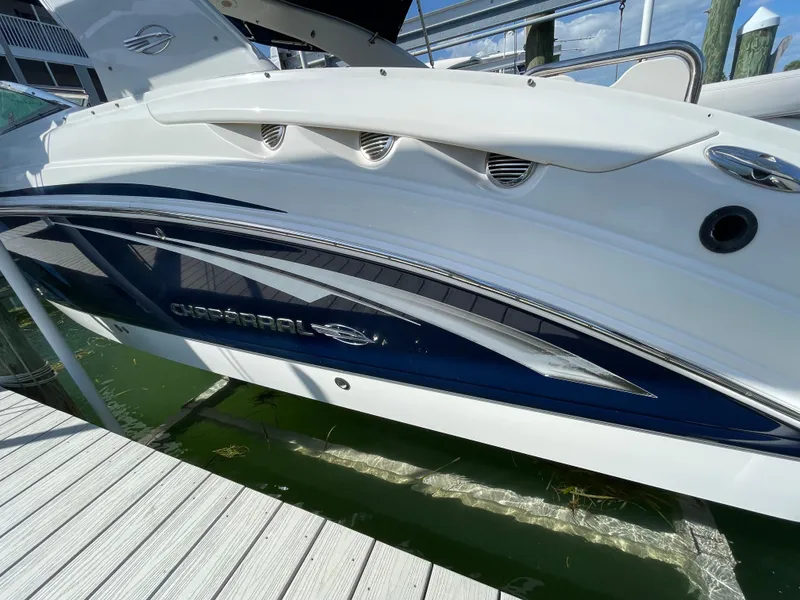 Slide: The Image of 2009 Chaparral 276 SSX boat docked, side view showing sleek design and branding. - 34