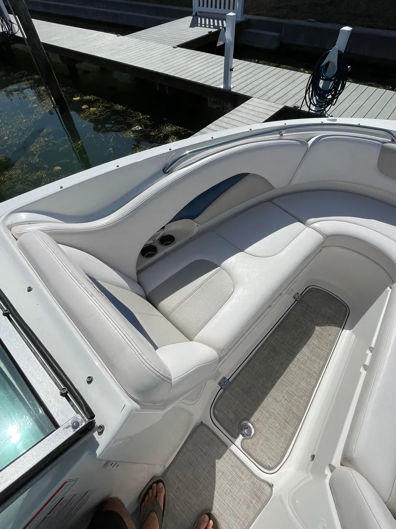 Slide: The Image of 2009 Chaparral 276 SSX boat interior with white seating and storage compartment. - 39