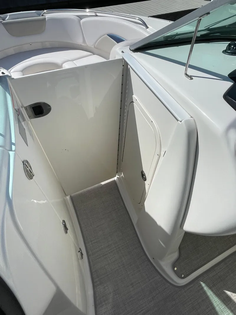 Slide: The Image of 2009 Chaparral 276 SSX boat interior with white seating and storage compartments. - 9