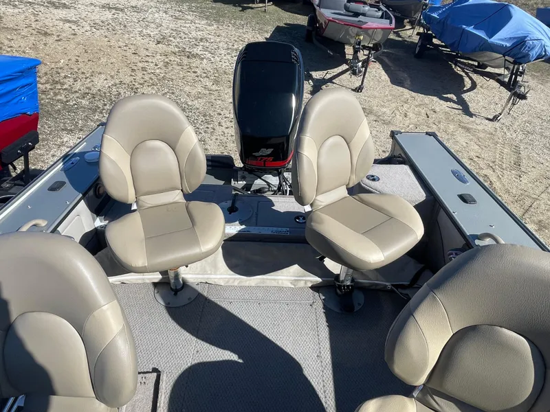 Slide: The Image of 2001 Lund 1900 Pro-V IFS boat interior with four beige seats and motor. - 10