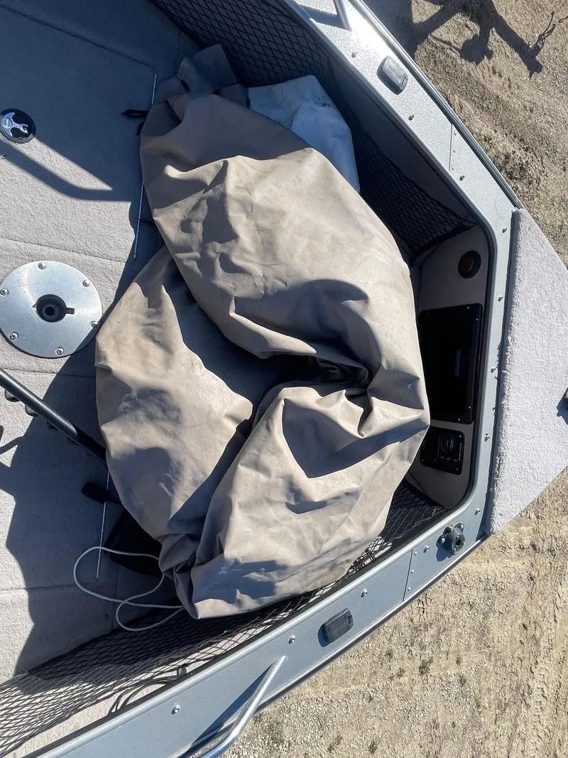 Slide: The Image of 2001 Lund 1900 Pro-V IFS boat interior with cover and storage compartments. - 11