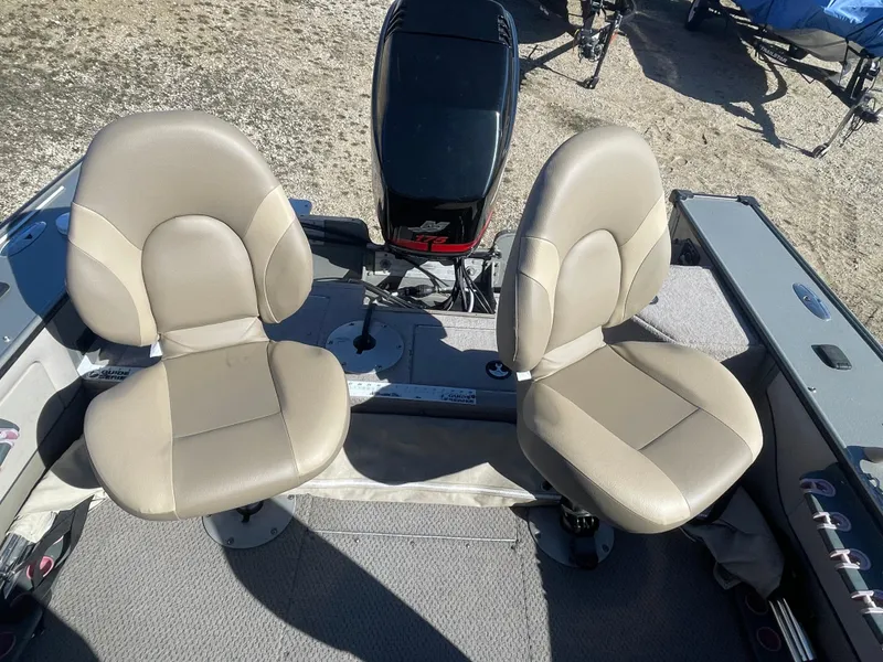 Slide: The Image of 2001 Lund 1900 Pro-V IFS boat interior with two beige seats and motor. - 6