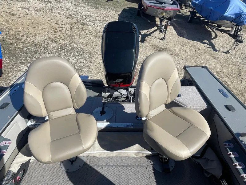 Slide: The Image of 2001 Lund 1900 Pro-V IFS boat interior with two beige seats and motor. - 7