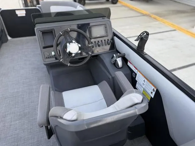 Slide: The Image of 2024 Manitou Cruise 22 Max Bench V-Toon boat cockpit with steering wheel and control panel. - 7