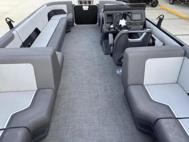 Slide: The Image of 2024 Manitou Cruise 22 Max Bench V-Toon interior with gray seating and steering console. - 9