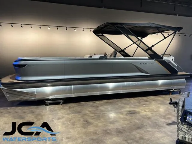 Slide: The Image of 2024 Manitou Explore 26 Switchback Single Engine V-Toon pontoon boat in showroom. - 1