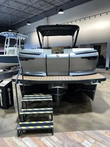 Slide: The Image of 2024 Manitou Explore 26 Switchback Single Engine V-Toon boat on display indoors. - 14