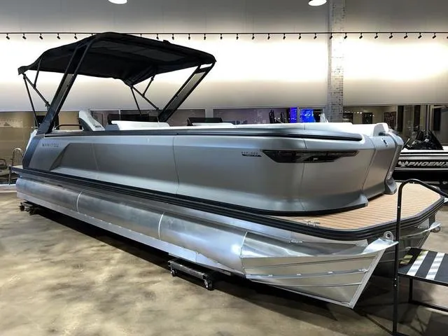 Slide: The Image of 2024 Manitou Explore 26 Switchback Single Engine V-Toon pontoon boat in showroom. - 4