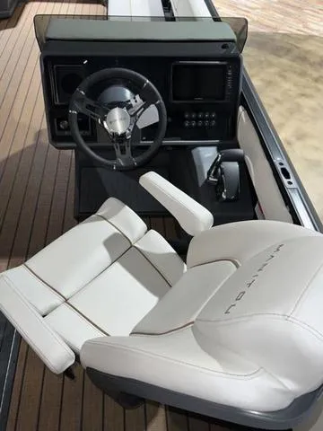 Slide: The Image of 2024 Manitou Explore 26 Switchback Single Engine V-Toon cockpit with steering wheel and captain's chair. - 8