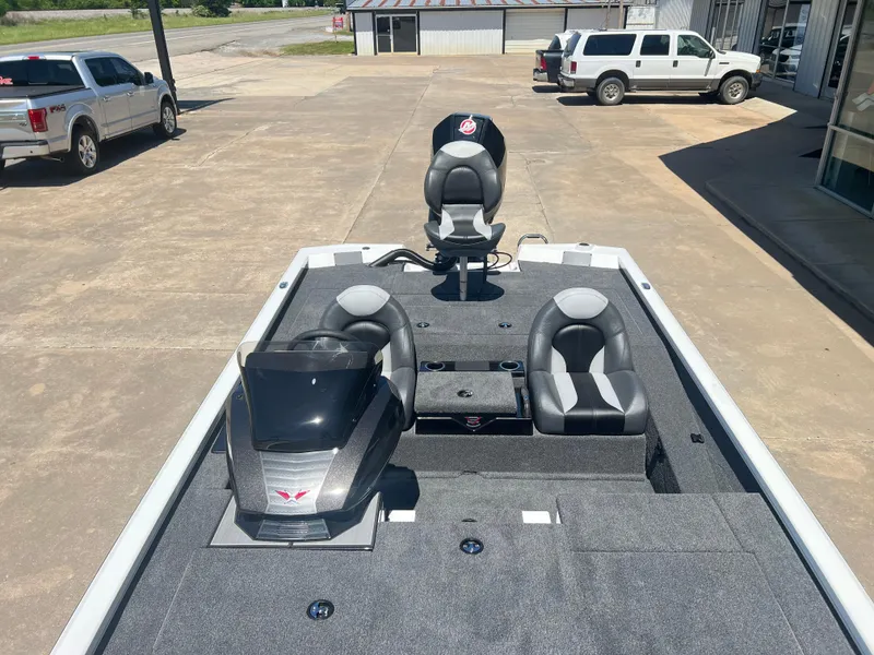 Slide: The Image of 2024 Vexus AVX 2080 boat interior with seating and console, parked outdoors. - 7