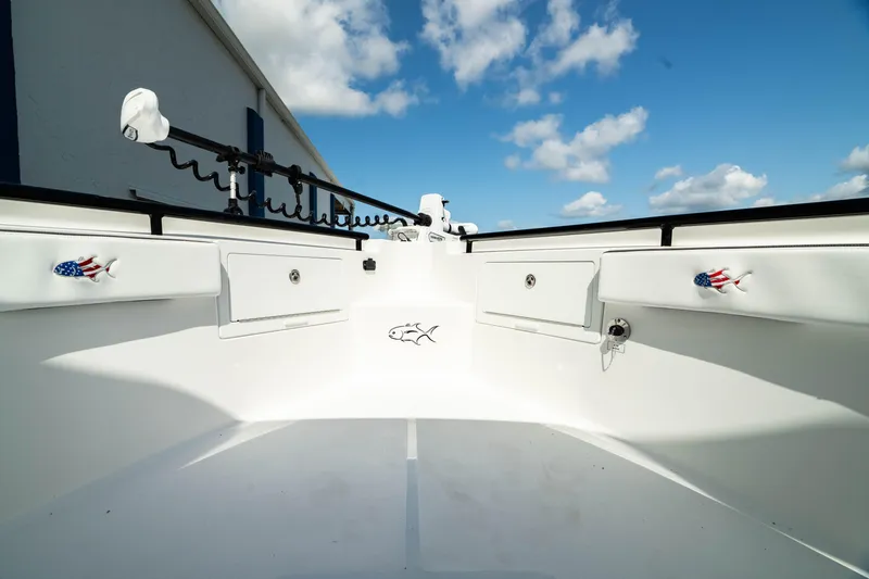 Slide: The Image of 2025 Crevalle 26 HBW boat deck with storage compartments and fishing rod holders. - 19