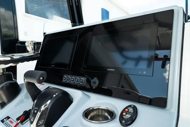 Slide: The Image of Control panel of 2025 Crevalle 26 HBW boat with dual screens and steering wheel. - 29