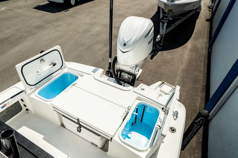 Slide: The Image of 2025 Crevalle 26 HBW boat stern with open storage compartments and outboard motor. - 32