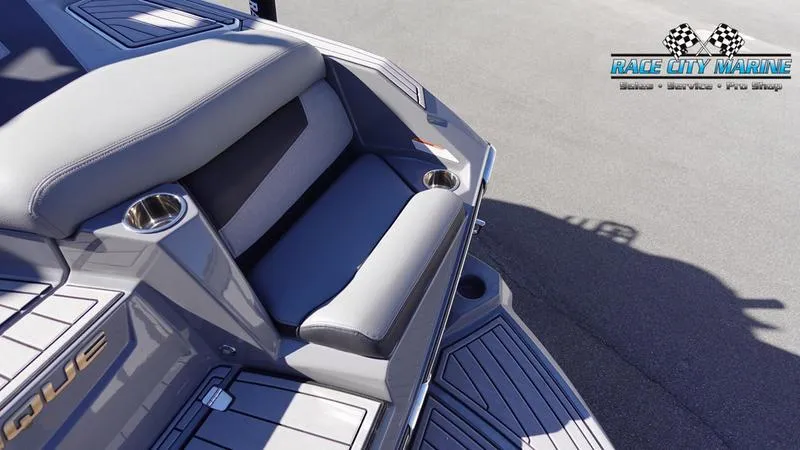 Slide: The Image of 2021 Nautique Super Air Nautique G25 boat seating with cup holders, Race City Marine logo. - 14