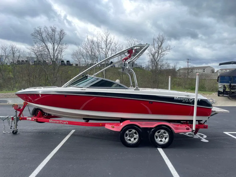 Slide: The Image of 2005 MasterCraft X-10 boat on a trailer, red and white, parked outdoors. - 3