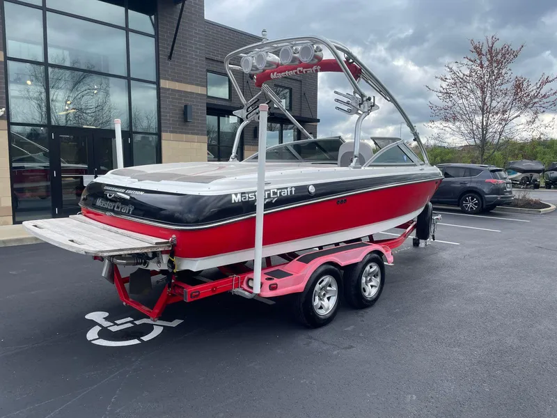 Slide: The Image of 2005 MasterCraft X-10 red and white boat on a trailer in a parking lot. - 5
