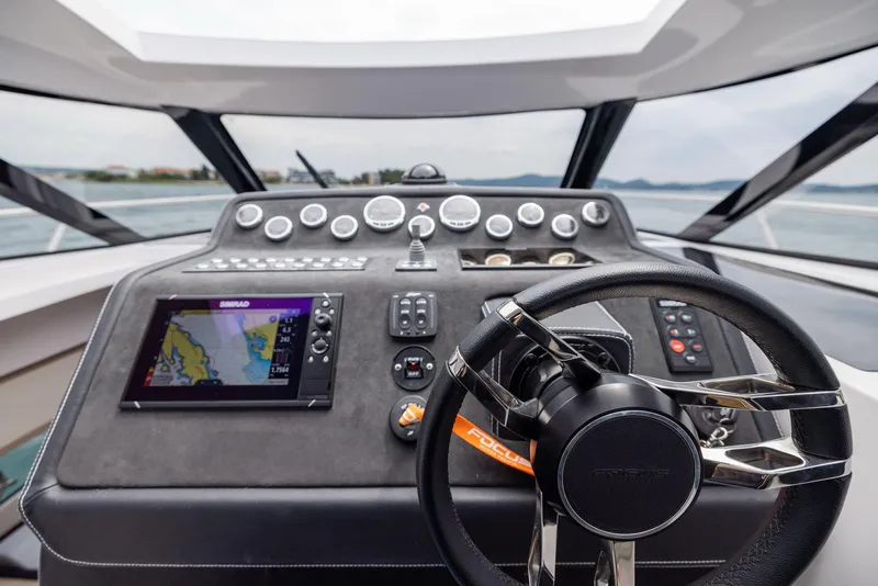 Slide: The Image of 2025 Focus Power 36 boat dashboard with navigation system and steering wheel. - 19
