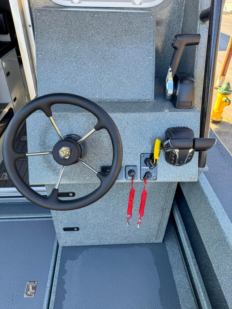 Slide: The Image of 2024 North River Endurance 2800EXL boat helm with steering wheel and controls. - 14