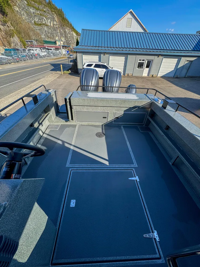 Slide: The Image of 2024 North River Endurance 2800EXL boat with dual outboard motors, docked near a building. - 15