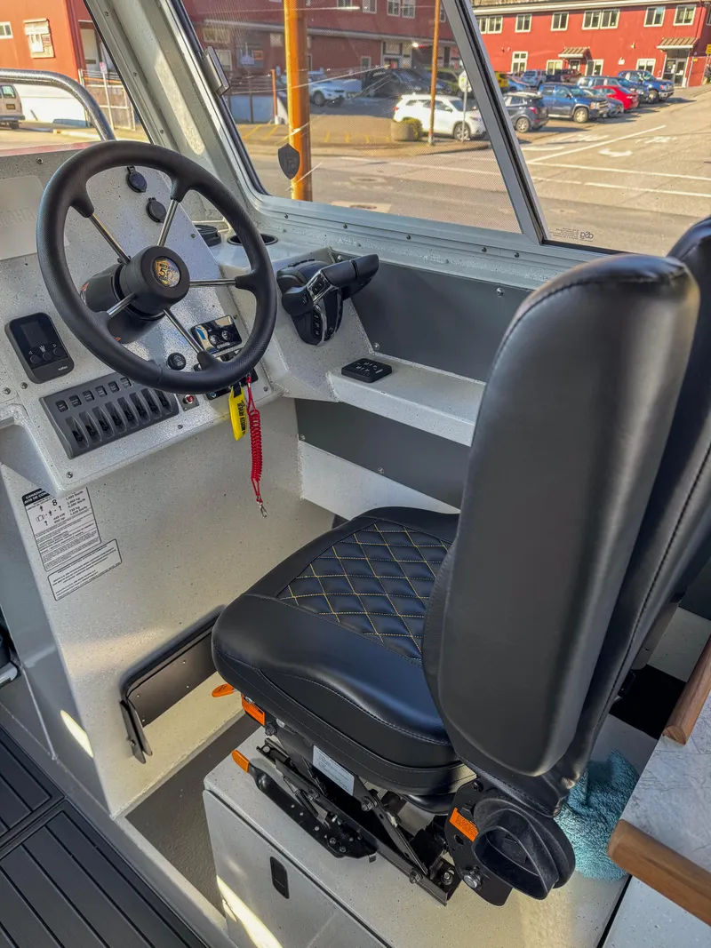 Slide: The Image of 2024 North River Endurance 2800EXL boat interior with captain's seat and steering wheel. - 3