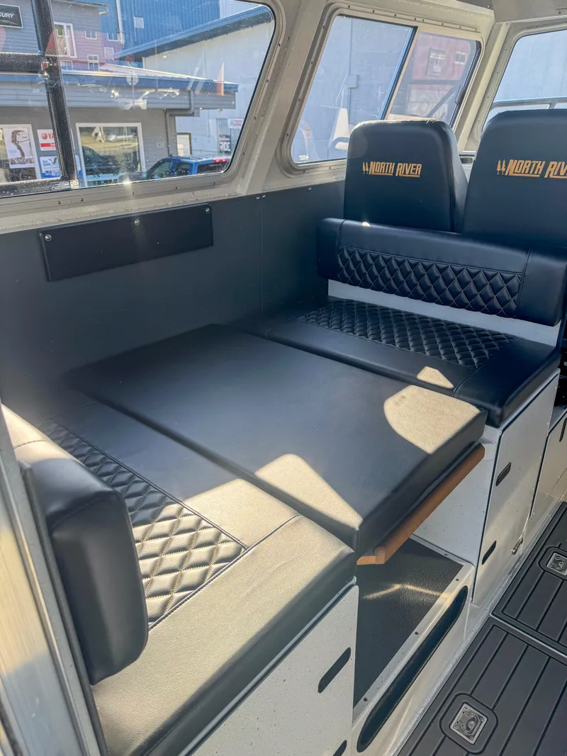 Slide: The Image of 2024 North River Endurance 2800EXL interior seating and storage area. - 6