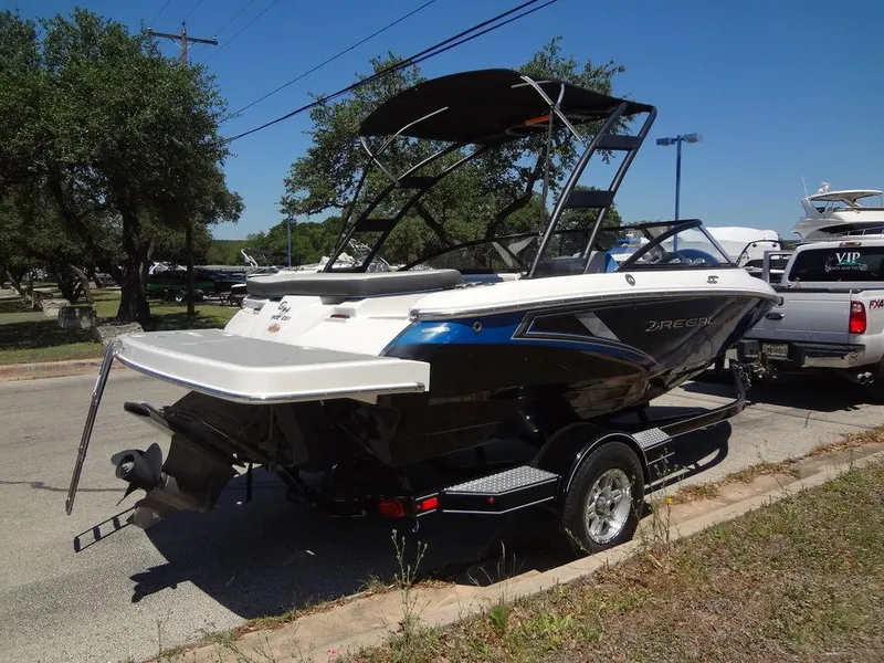 Slide: The Image of 2019 Regal 1900 ESX boat on a trailer, parked outdoors. - 5