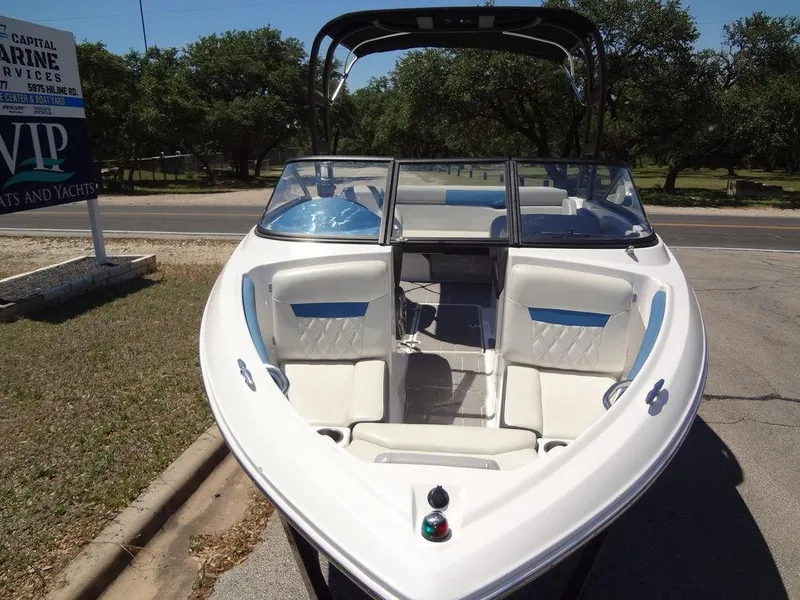 Slide: The Image of 2019 Regal 1900 ESX boat with white and blue interior, parked on a sunny day. - 8