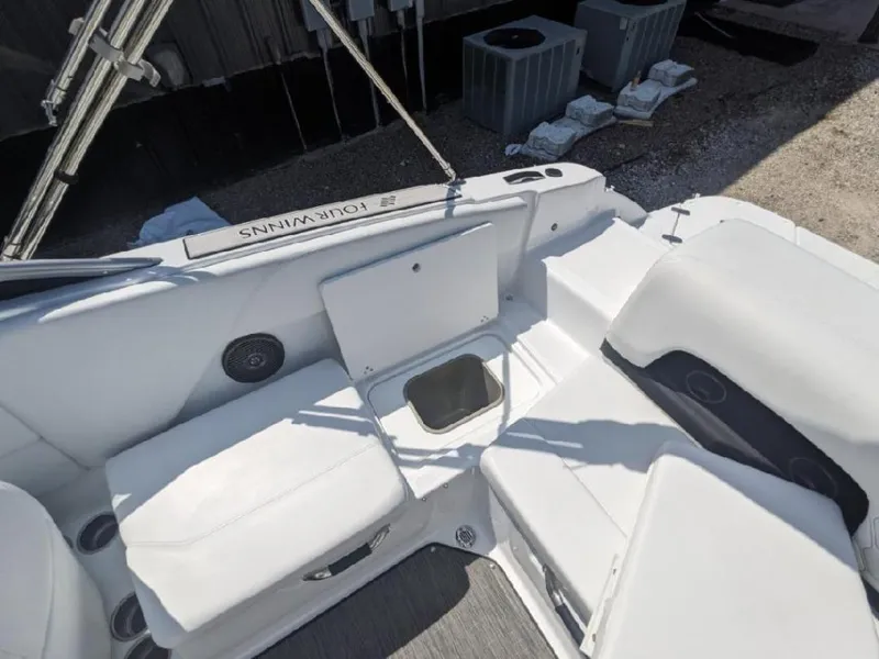Slide: The Image of 2023 Four Winns H1 OB boat interior with white seating and storage compartment. - 18
