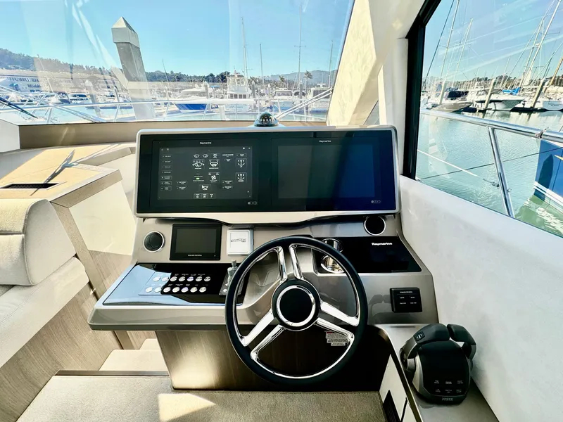 Slide: The Image of Helm of 2025 Galeon 500 Fly yacht with modern controls and marina view. - 23