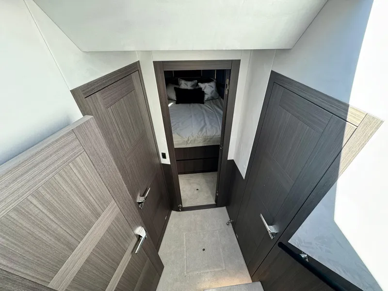 Slide: The Image of Interior of 2025 Galeon 500 Fly yacht, featuring modern wood doors and a cozy bedroom. - 25