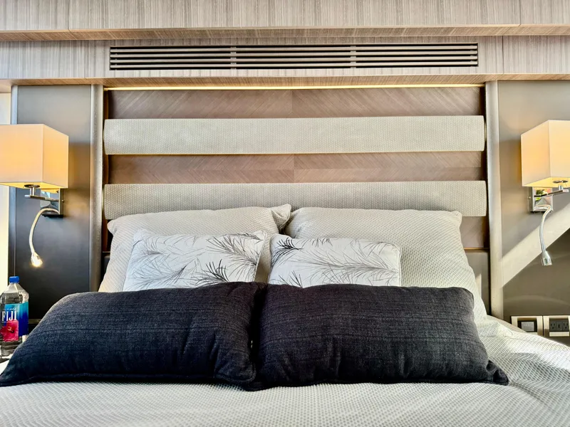 Slide: The Image of Luxurious bedroom interior on 2025 Galeon 500 Fly yacht, featuring elegant bedding and modern lighting. - 36