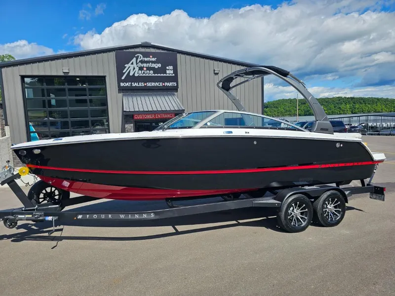 The Image of 2025 Four Winns H4 boat on trailer outside dealership. - 1