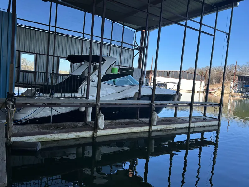 Slide: The Image of 2016 Sea Ray 330 Sundancer docked in a covered marina slip. - 12