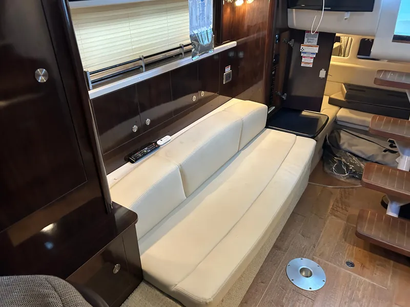 Slide: The Image of Interior of 2016 Sea Ray 330 Sundancer with beige seating and wooden accents. - 32
