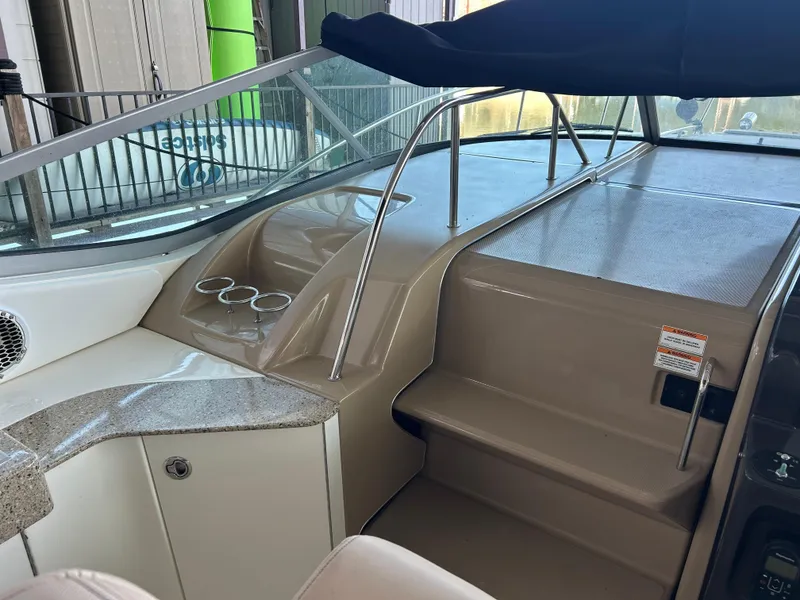Slide: The Image of 2016 Sea Ray 330 Sundancer cockpit with beige interior and cup holders. - 38