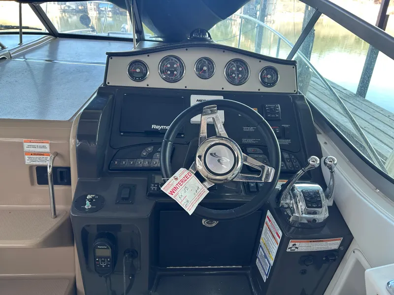 Slide: The Image of 2016 Sea Ray 330 Sundancer helm with steering wheel and control panel. - 39