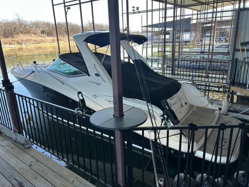 Slide: The Image of 2016 Sea Ray 330 Sundancer docked in a marina, covered and ready for use. - 42