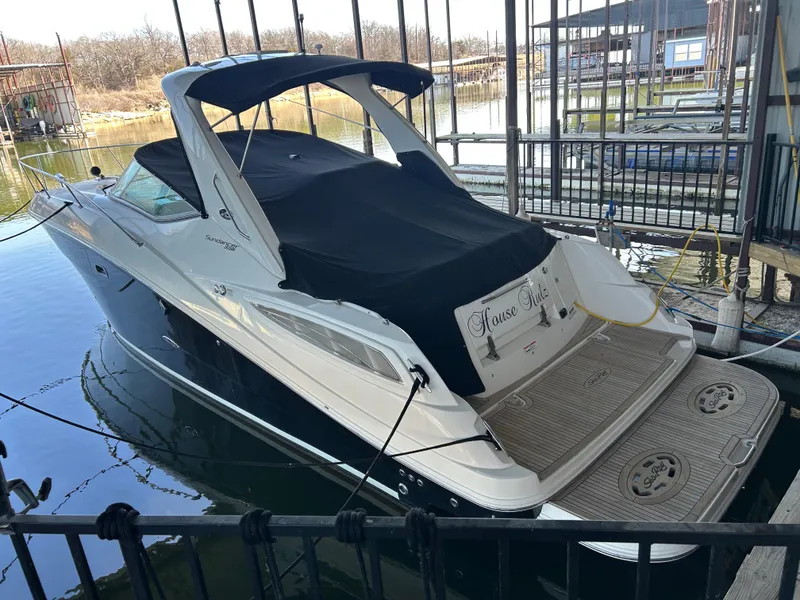Slide: The Image of 2016 Sea Ray 330 Sundancer docked, featuring sleek design and covered seating area. - 43